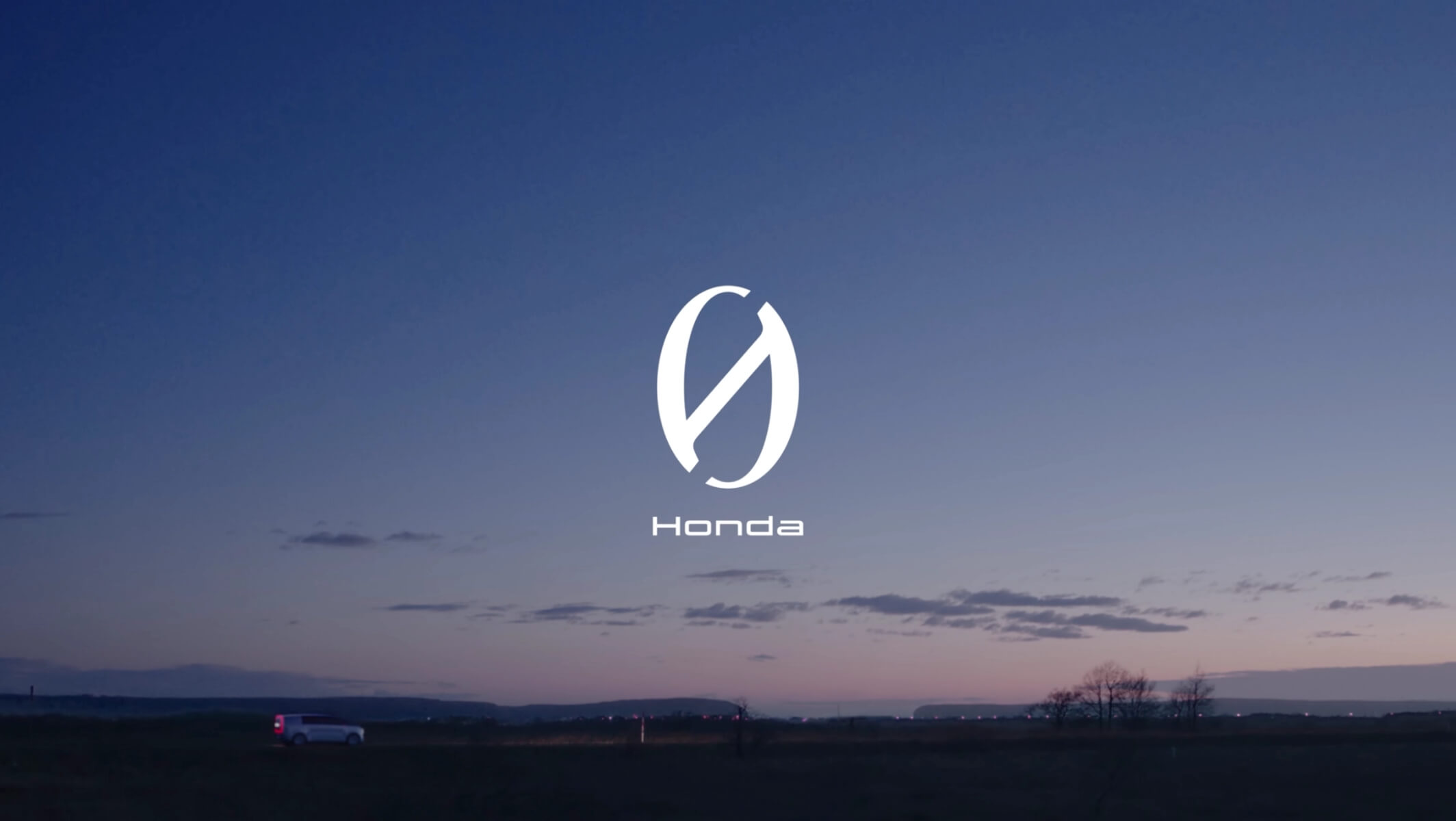 Une scène de crépuscule sereine avec le logo Honda et le texte "Honda" en blanc au centre sur un ciel dégradé, avec un véhicule blanc isolé roulant sur une route sombre en bas.